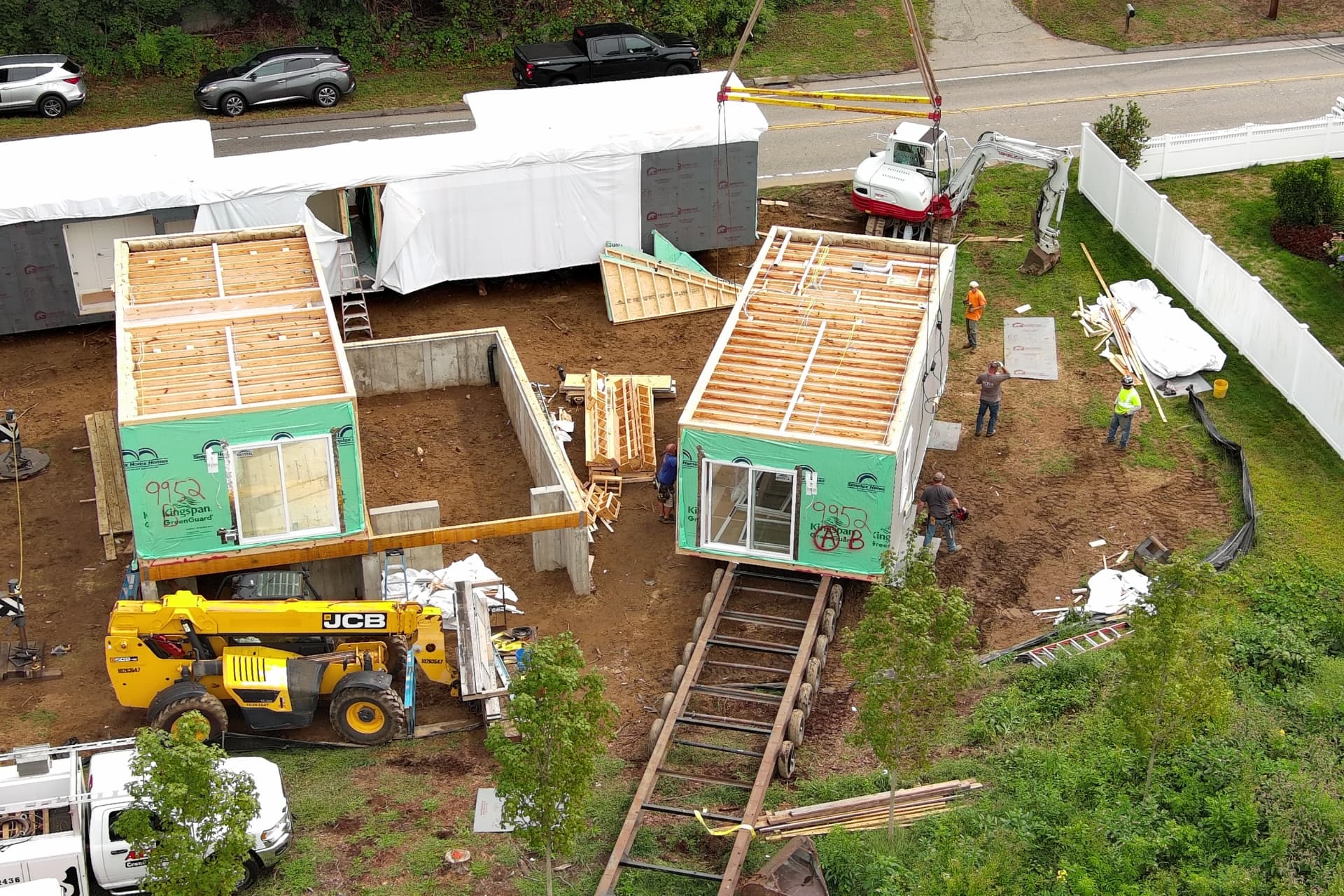 Modular home sections with factory-built roof framing waiting for the crane set in Connecticut